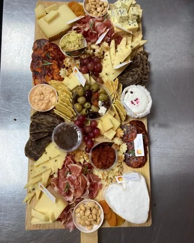 Borrelplank voor 8 personen: lange plank vol kazen, vleeswaren, dips, olijven, noten en crackers
