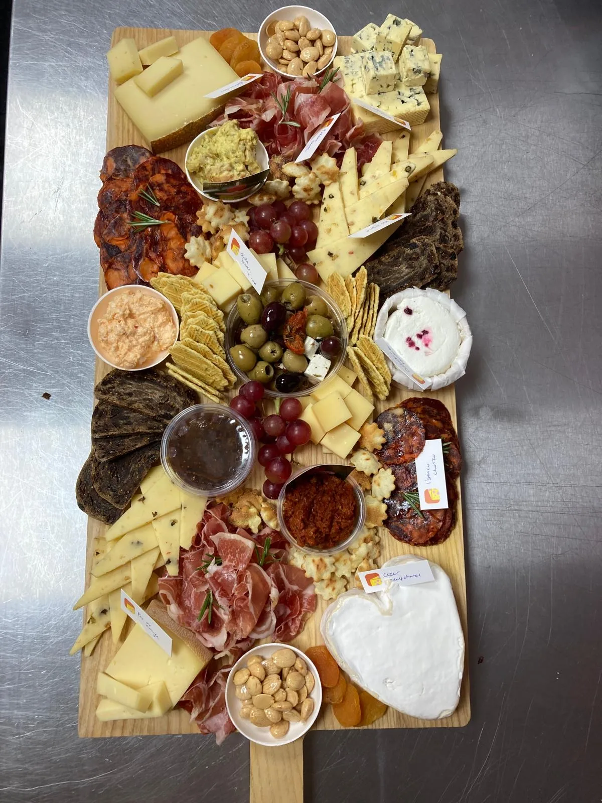 Lange borrelplank met kaas, vleeswaren, dips, olijven en toastjes