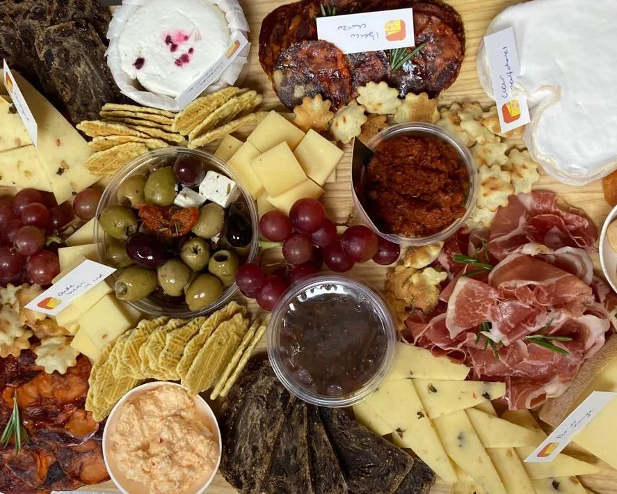 Lange borrelplank met kaas, vleeswaren, dips, olijven en toastjes